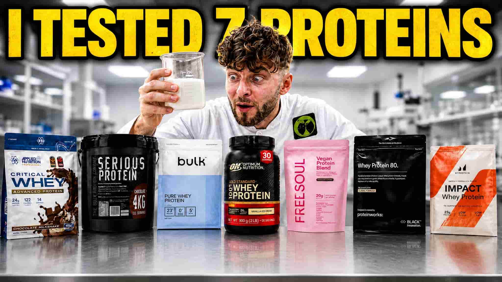 Logan holding a beaker of milk behind seven protein powders